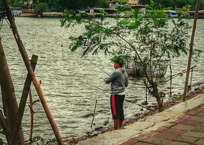 Rear view of man standing by river