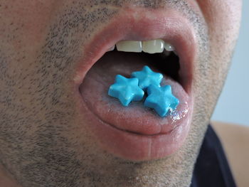 Close-up of man eating blue candies