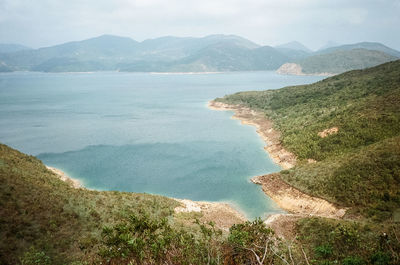 High angle view of sea and mountains against sky