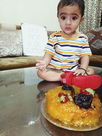 Portrait of boy with ice cream on table