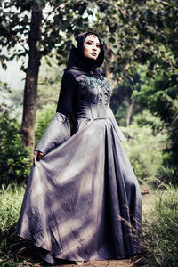 Young woman wearing witch costume while standing outdoors