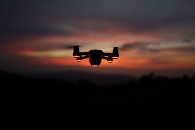 Silhouette airplane against sky during sunset