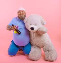 Man holding toy against pink background