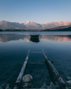Rowboat on lake against clear sky
