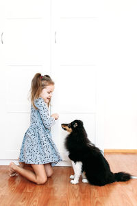 Woman with cat sitting on wooden floor