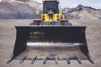 Close-up of construction machinery against mountains