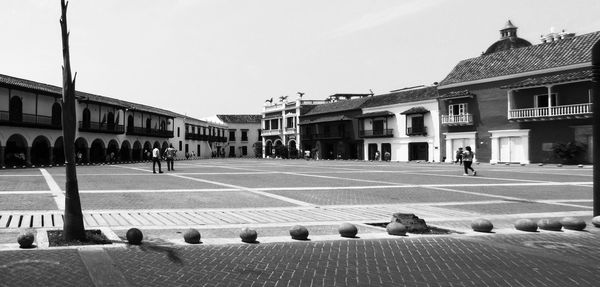 People on street against buildings in city