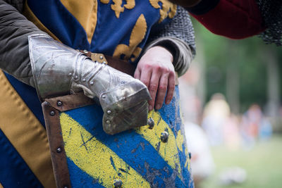 Midsection of person in costume holding shield