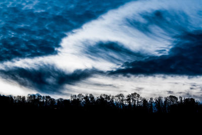 Low angle view of silhouette trees against sky