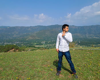 Young man standing in nature looking left side