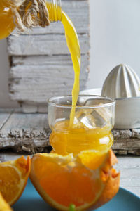 Freshly made orange juice in a ceramic squeezer, poured into a crystal