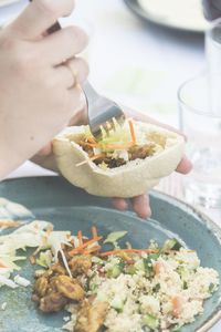 Hand filling pitta bread with tabouleh salad