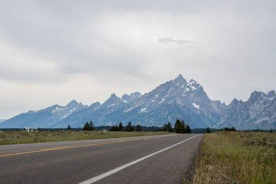 Road by mountains against sky