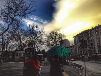 Rear view of people walking on road against buildings