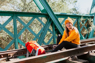 Woman trekking rests on an abandoned railway track