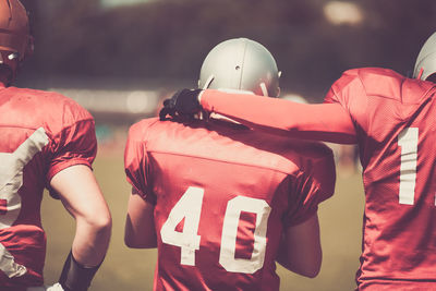 Rear view of american football players on field