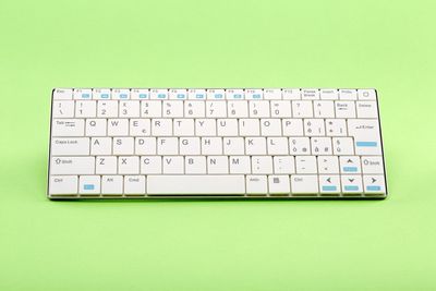 High angle view of computer keyboard against green background