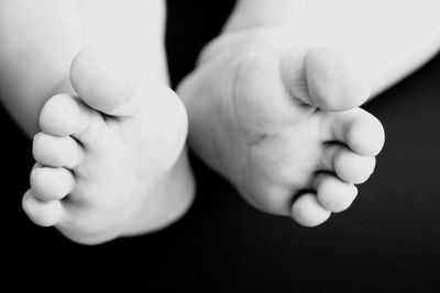 Low section of baby boy against black background