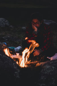 Girl in front of a campfire thinking