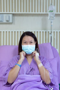 Portrait of a young woman sitting on bed