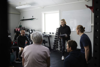 Smiling people talking together in gym