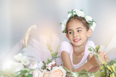 Portrait of woman with rose bouquet against white wall