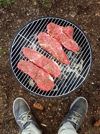 Low section of man standing on barbecue grill