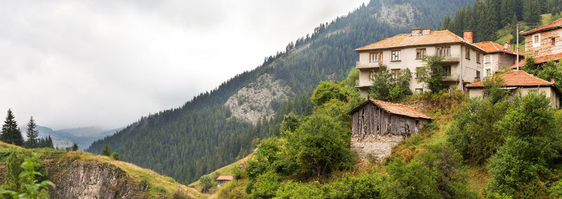 Panoramic view of trees and houses against sky