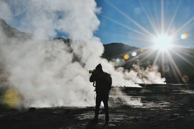 Rear view of man standing in sun