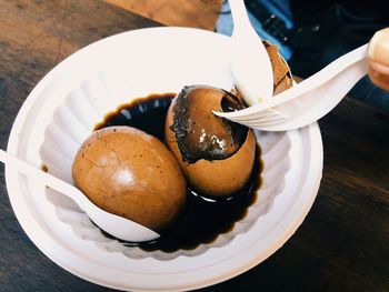 Cropped image of person handing egg dessert served on table