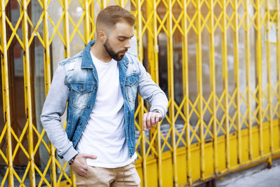 Young man looking at time on wristwatch person