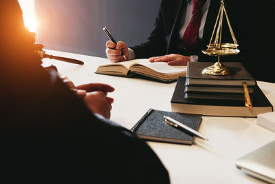 Cropped image of man reading book on table