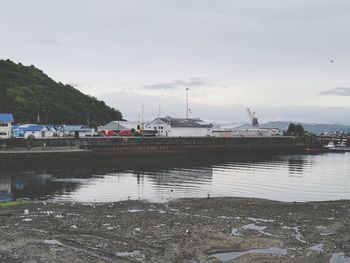 Boats moored at harbor against sky