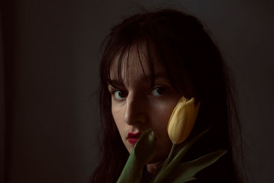 Close-up portrait of woman holding tulip