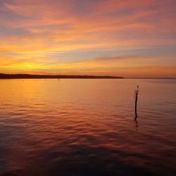 Scenic view of sea against orange sky