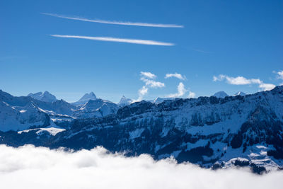 Scenic view of snowcapped mountains against blue sky