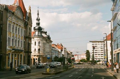 View of city street and buildings against sky