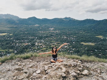 Woman standing on mountain against sky