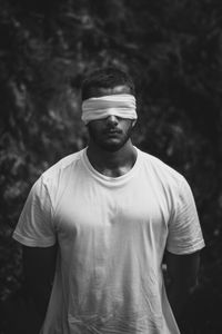 Man with blindfold standing outdoors