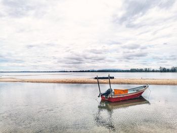 Boat moored on sea against sky