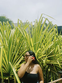 Portrait of young woman standing against a bush in fiji 