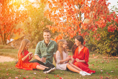 People sitting on sidewalk during autumn