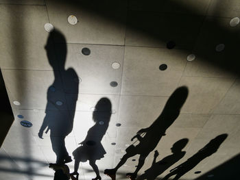 Shadow of people walking on tiled floor