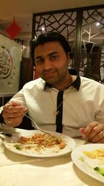 Portrait of young man sitting in restaurant