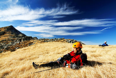 Rear view of woman standing on field against sky