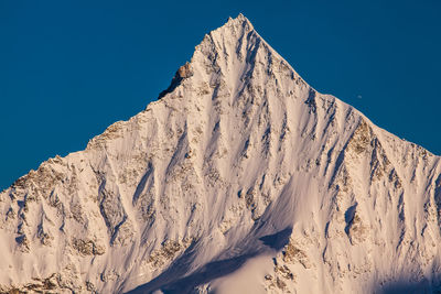 Scenic view of snowcapped mountains against clear blue sky