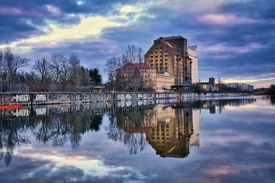 Reflection of buildings in lake at sunset