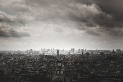 Aerial view of buildings in city against sky