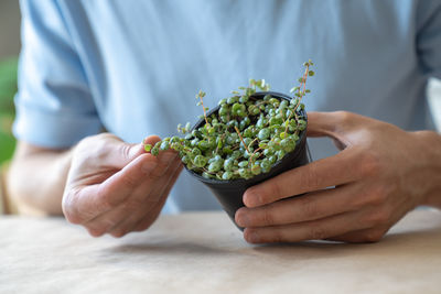 Midsection of man holding plant