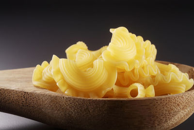 Close-up of yellow cake on table against black background